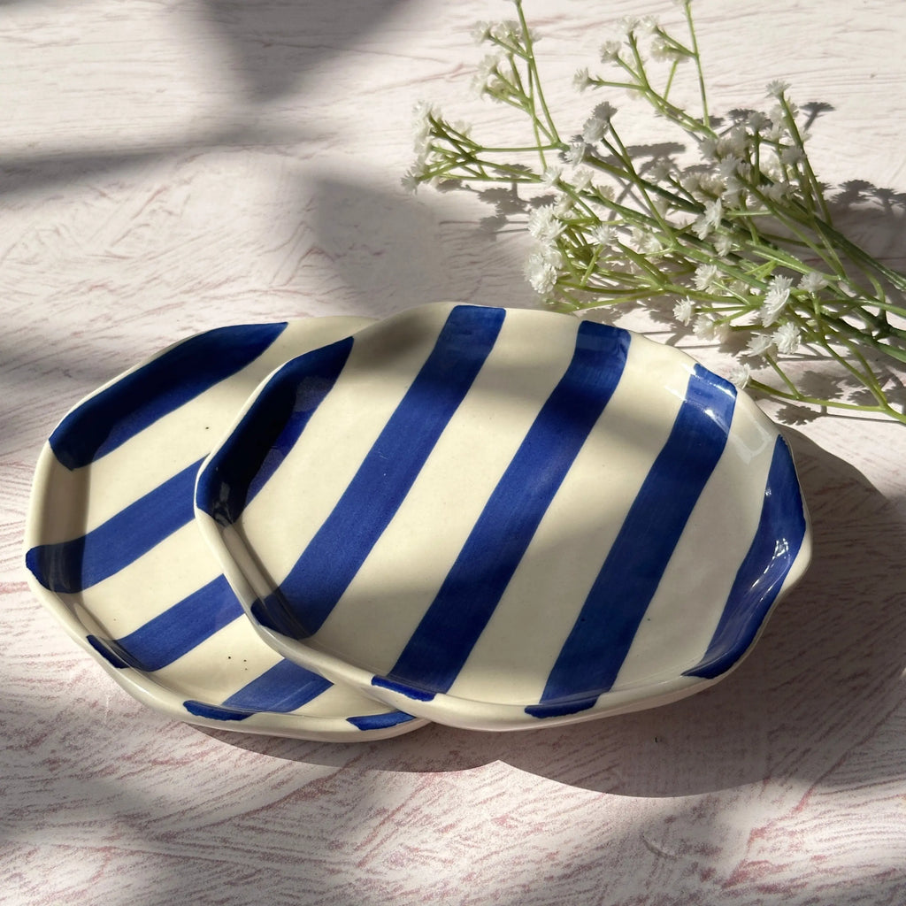 Set of four blue and white striped hand-painted plates for a coastal dining table