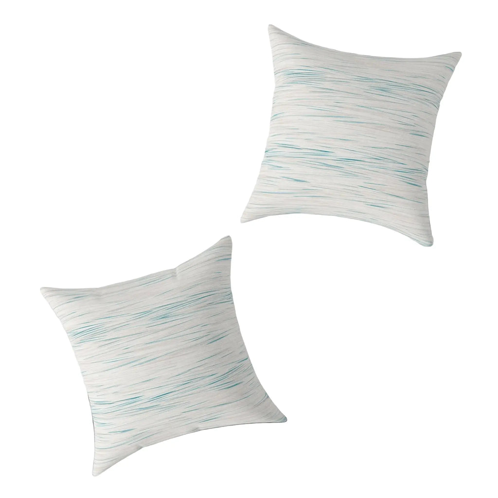 Two Coastal Breeze square pillows with blue watercolor stripes on a light linen-like cover.