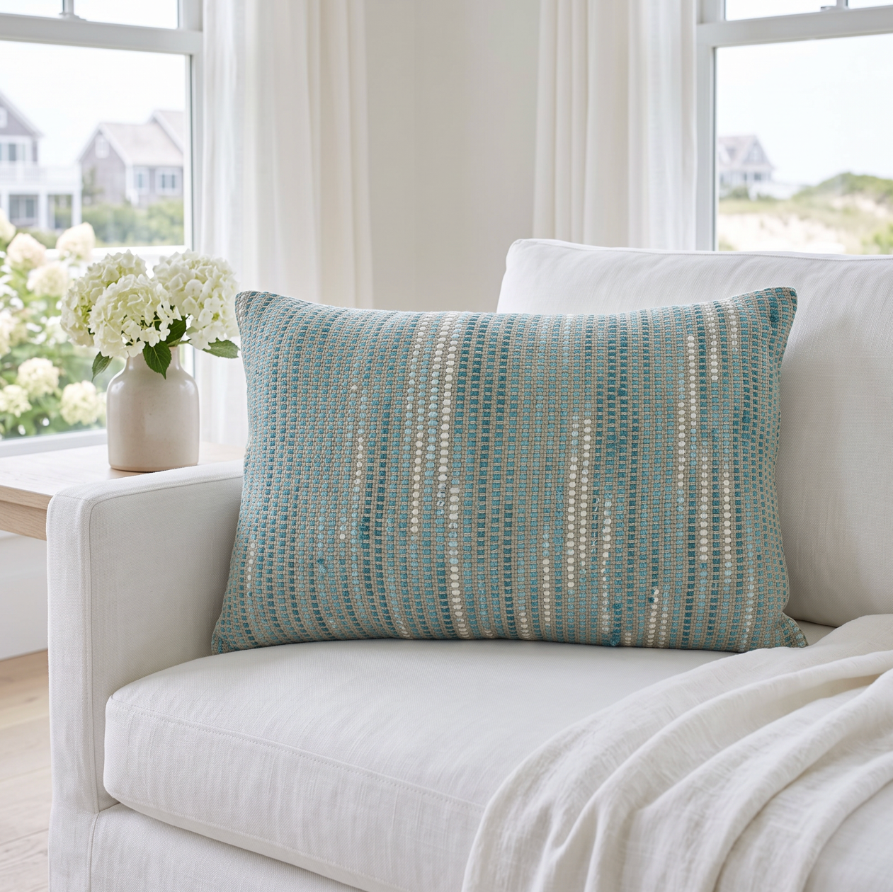 Decorative aqua blue woven stripe pillow in a 16 by 24 inch oblong shape for coastal living room decor.