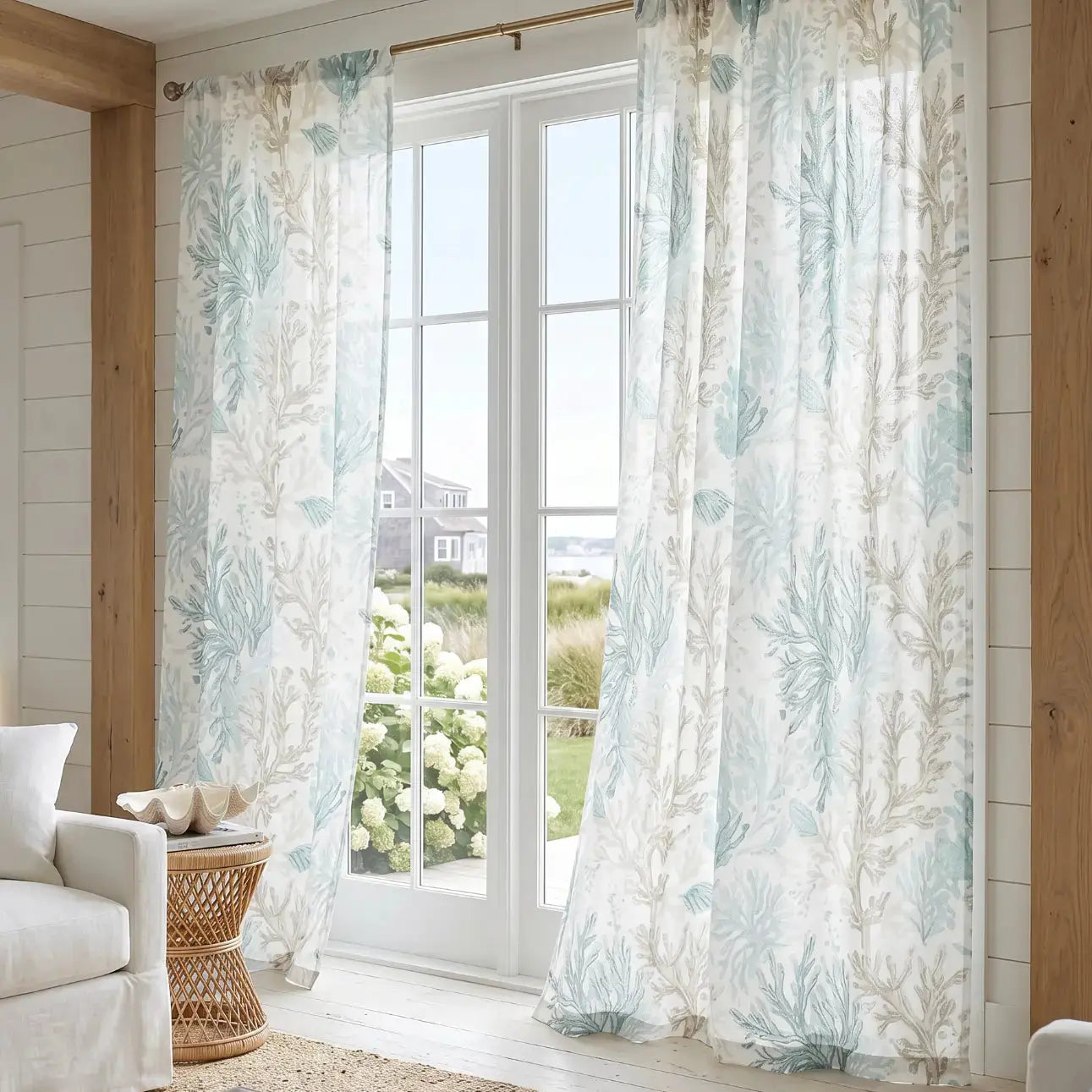 Aqua coral reef pattern sheer curtains on a sliding glass door in a beach house