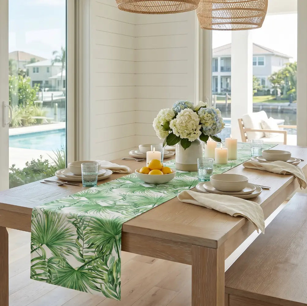 Green palm leaf table runner styled with white dinnerware and tropical decor.