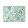 Aqua floral glass cutting board with large outlined flowers in soft seafoam, blue‑green, and cream tones.