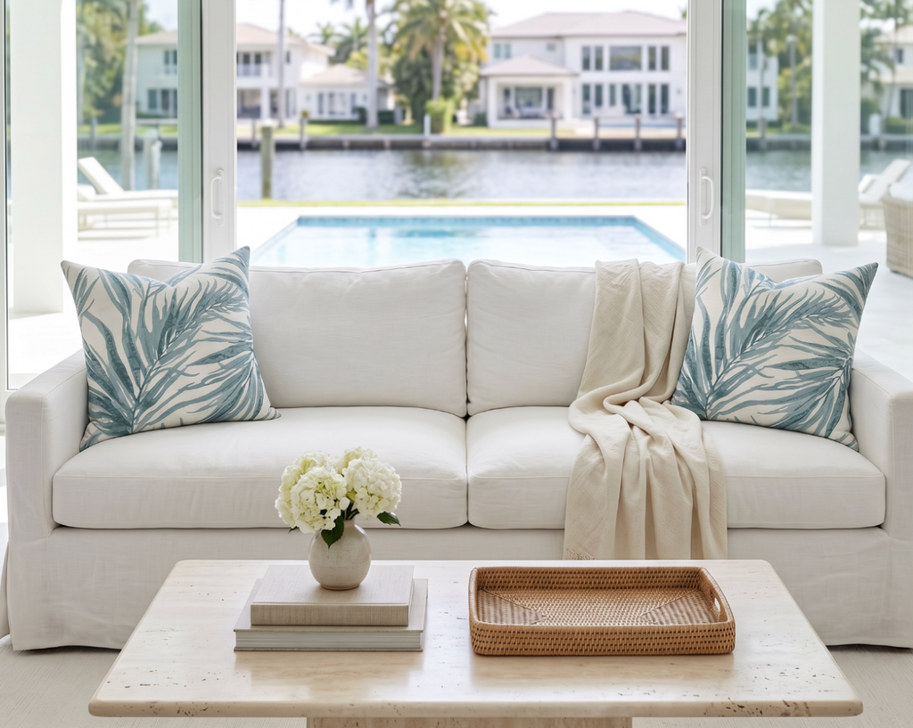 Aqua tropical palm print decorative pillow styled on a beach house couch