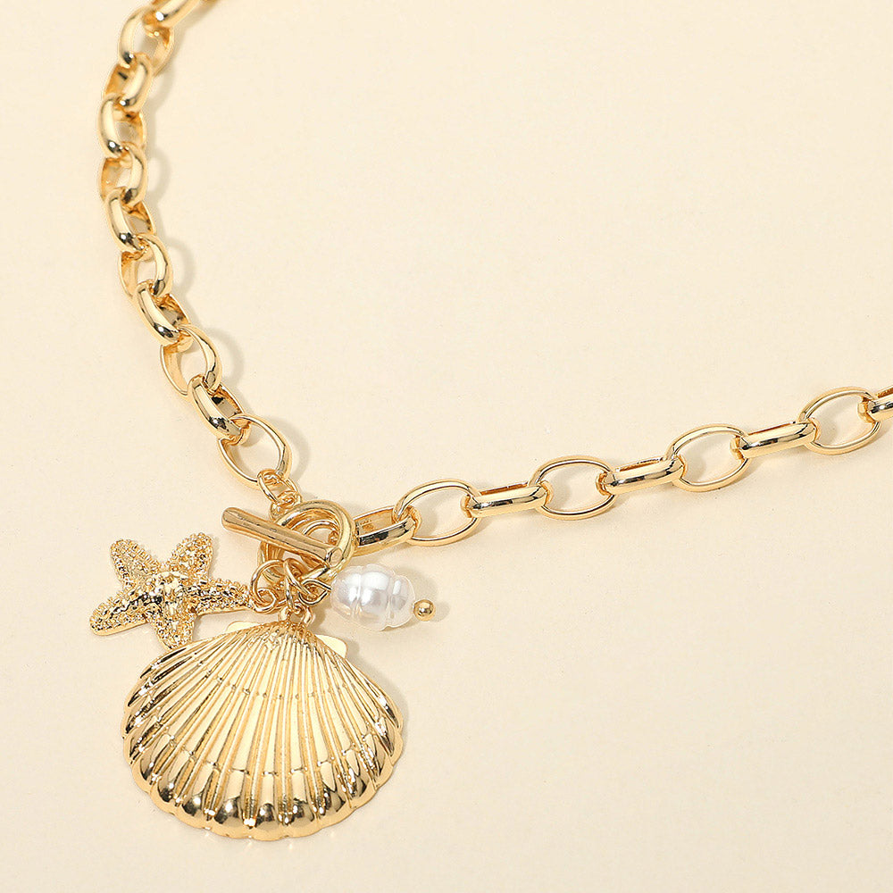 Nautical starfish and seashell pearl charm toggle necklace styled as a beach glam statement piece.