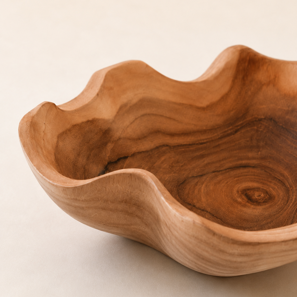 Beach house inspired teak bowl with a warm earthy tone and flowing shape.