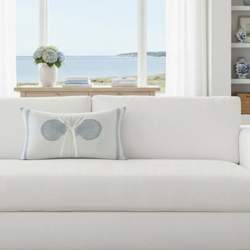 Coastal Seashell Decorative Lumbar Pillow on white sofa, seashell motif, 12x20 oblong lumbar silhouette.