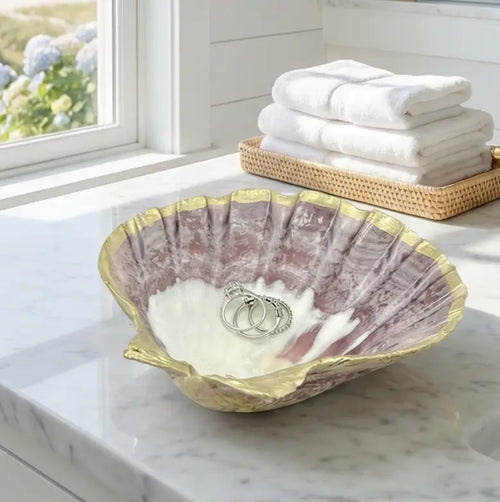 Natural seashell dish displaying earrings and rings in bathroom vignette