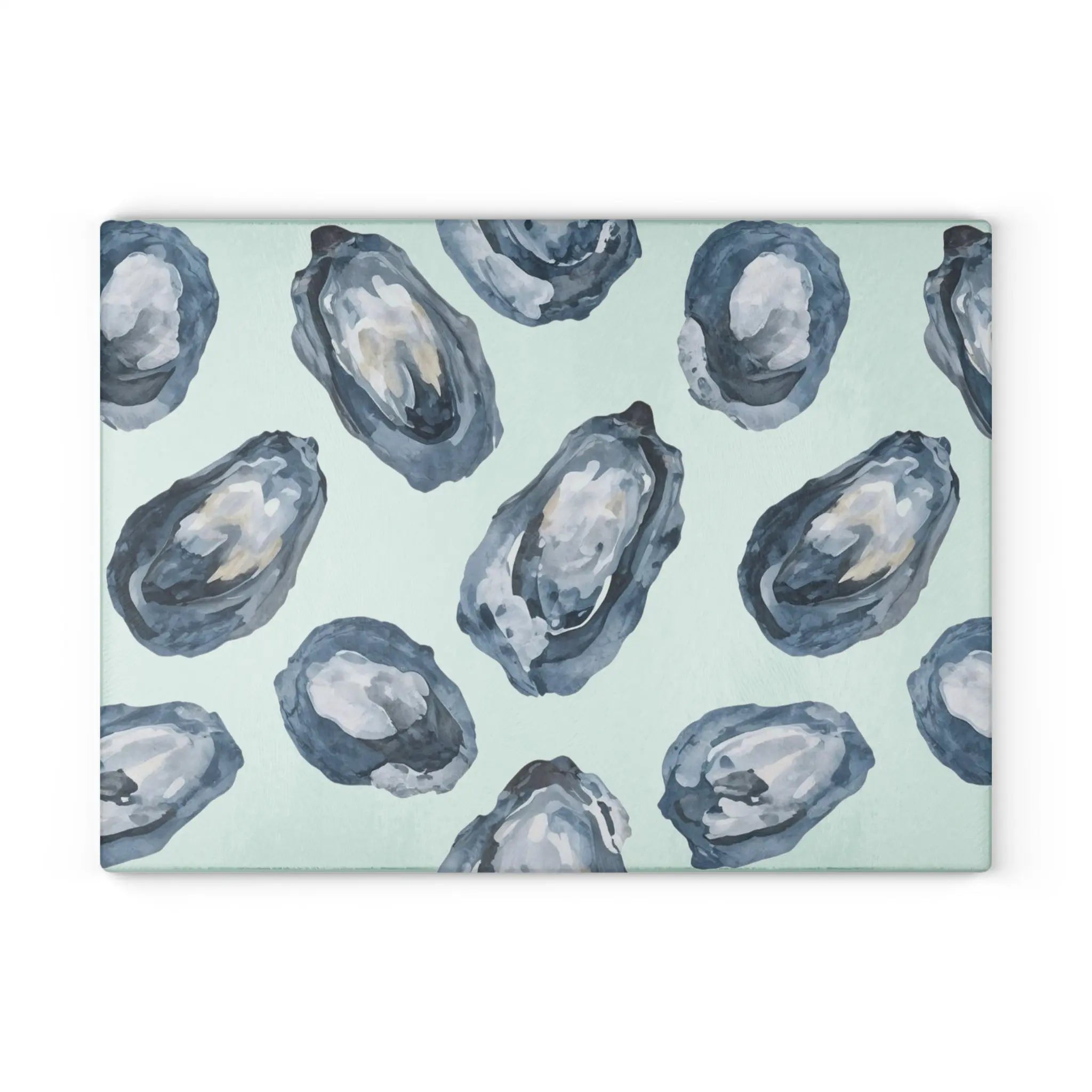 Oyster-patterned tempered glass cutting and serving board with blue-gray oyster motifs on pale mint background.
