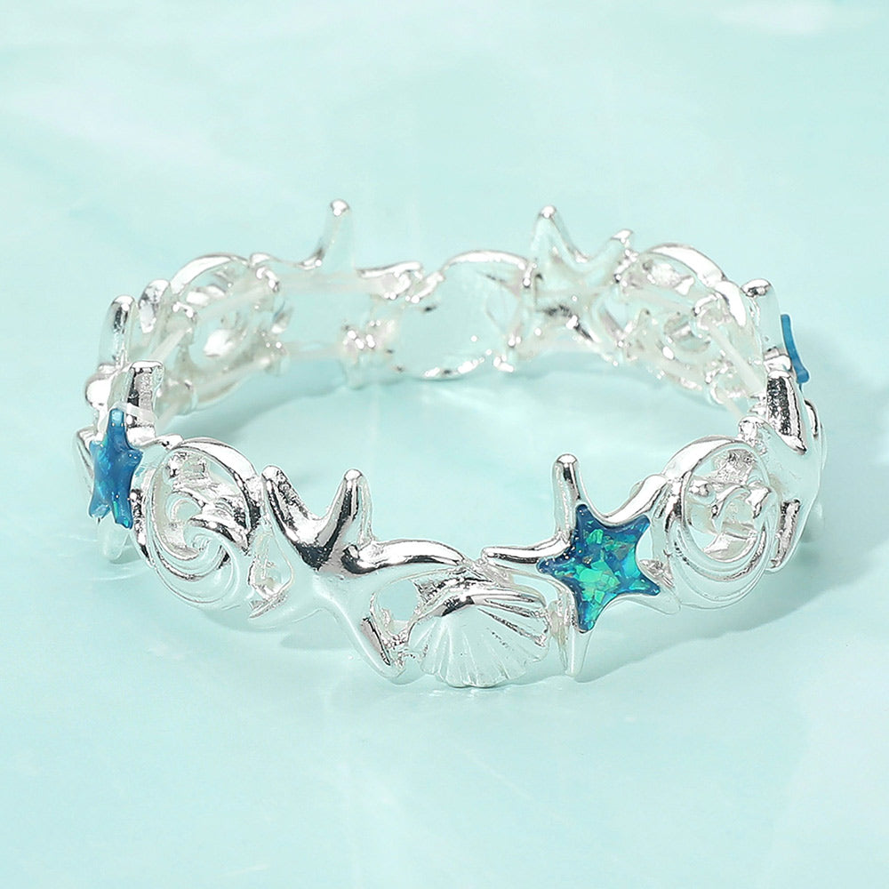 Beachy starfish shell wave link bracelet used as coastal stretch jewelry stacked with other bangles