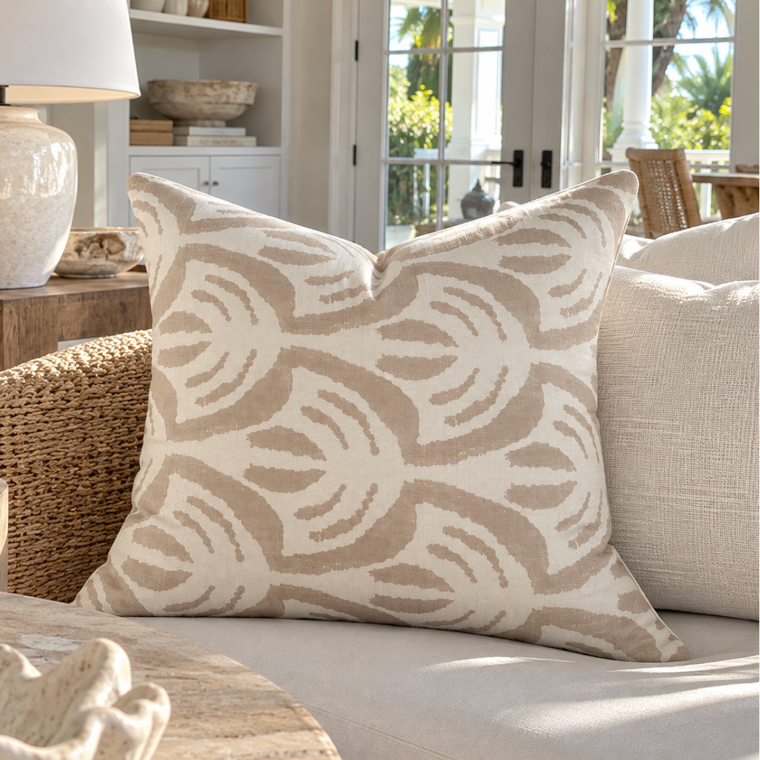Beige and ivory decorative throw pillow styled in a luxury coastal home.