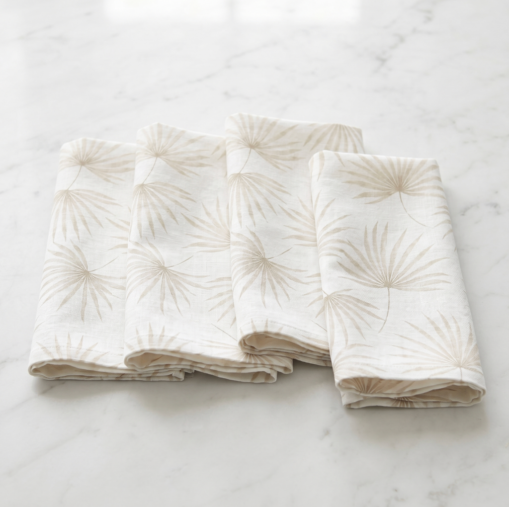 Beige palm motif linen napkins, set of four, styled with coastal place settings for casual entertaining.