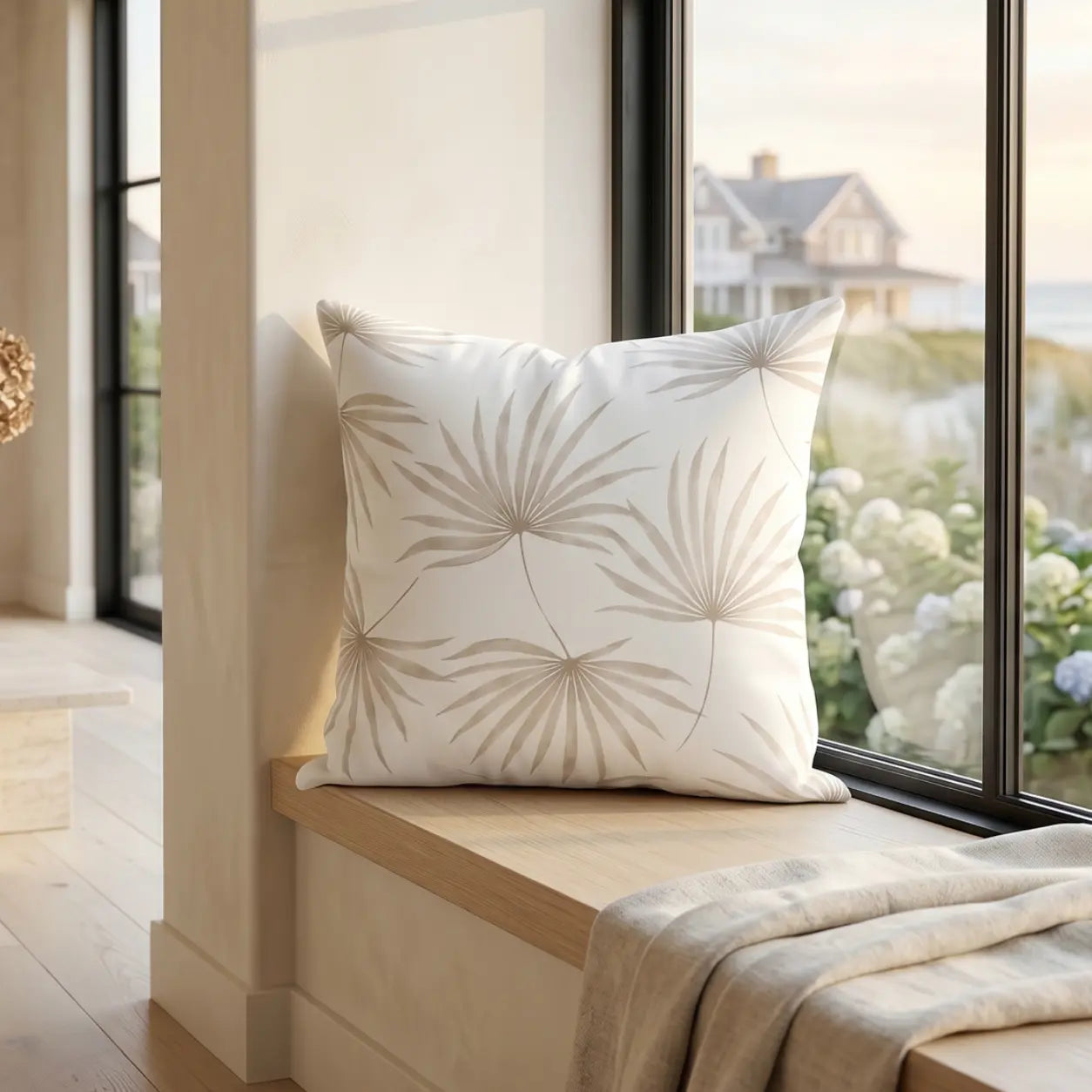 Beige palm leaf pillow styled on a neutral coastal sofa