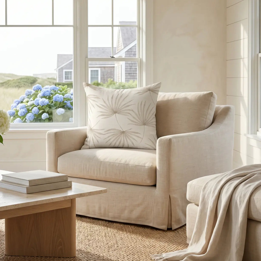 Beige palm leaf throw pillow on a sofa in a coastal living room