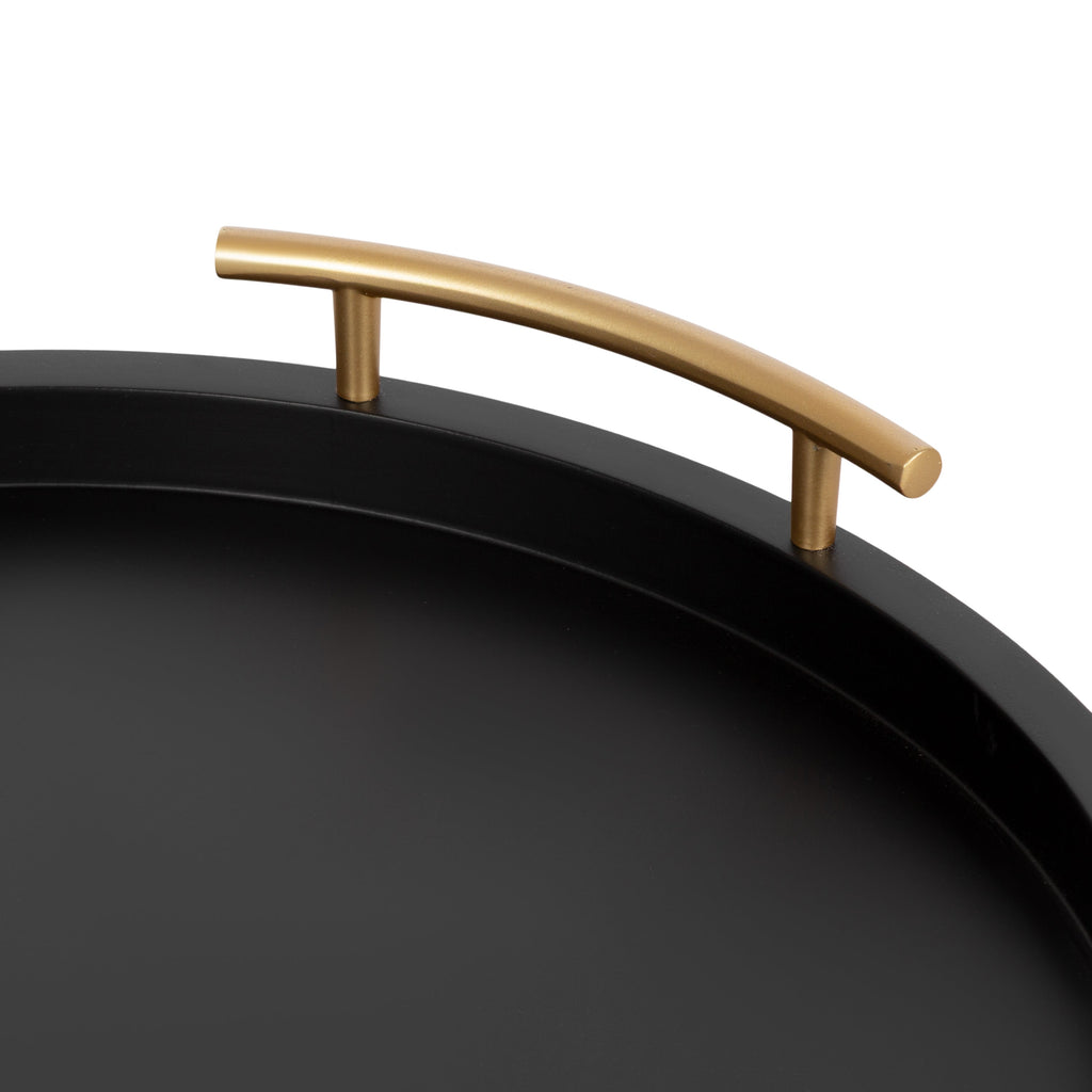 Black round decorative tray styled on a coffee table