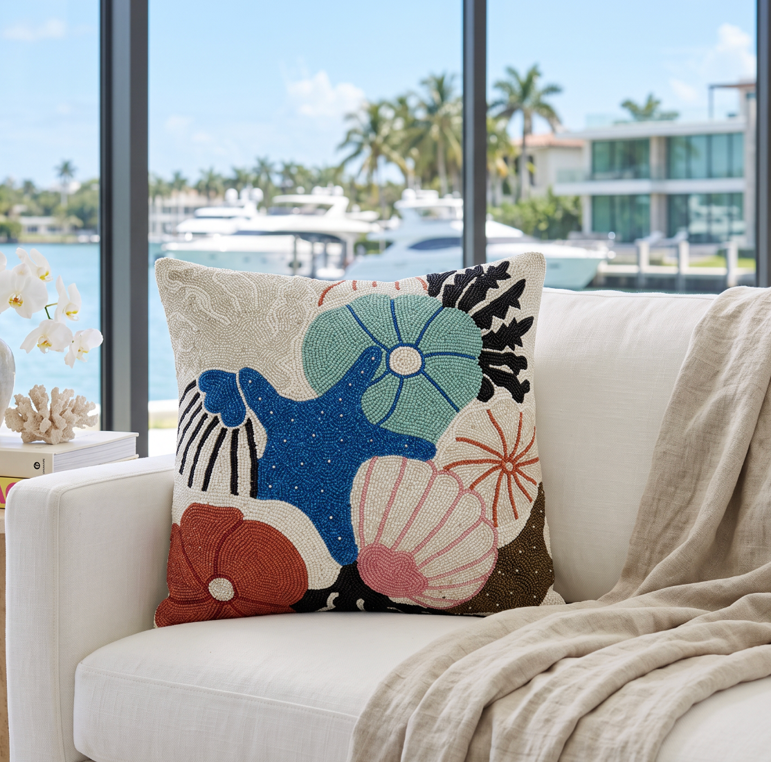 Hand‑embroidered seashell throw pillow with beadwork that glitters in natural or lamp light.
