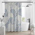 Blue and white fan shell coastal shower curtain hanging in a bright beach inspired bathroom