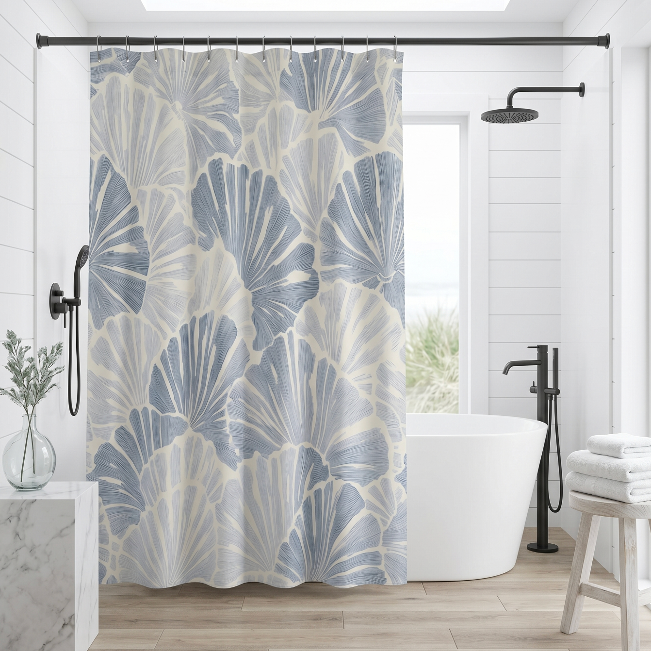 Blue and white fan shell coastal shower curtain hanging in a bright beach inspired bathroom