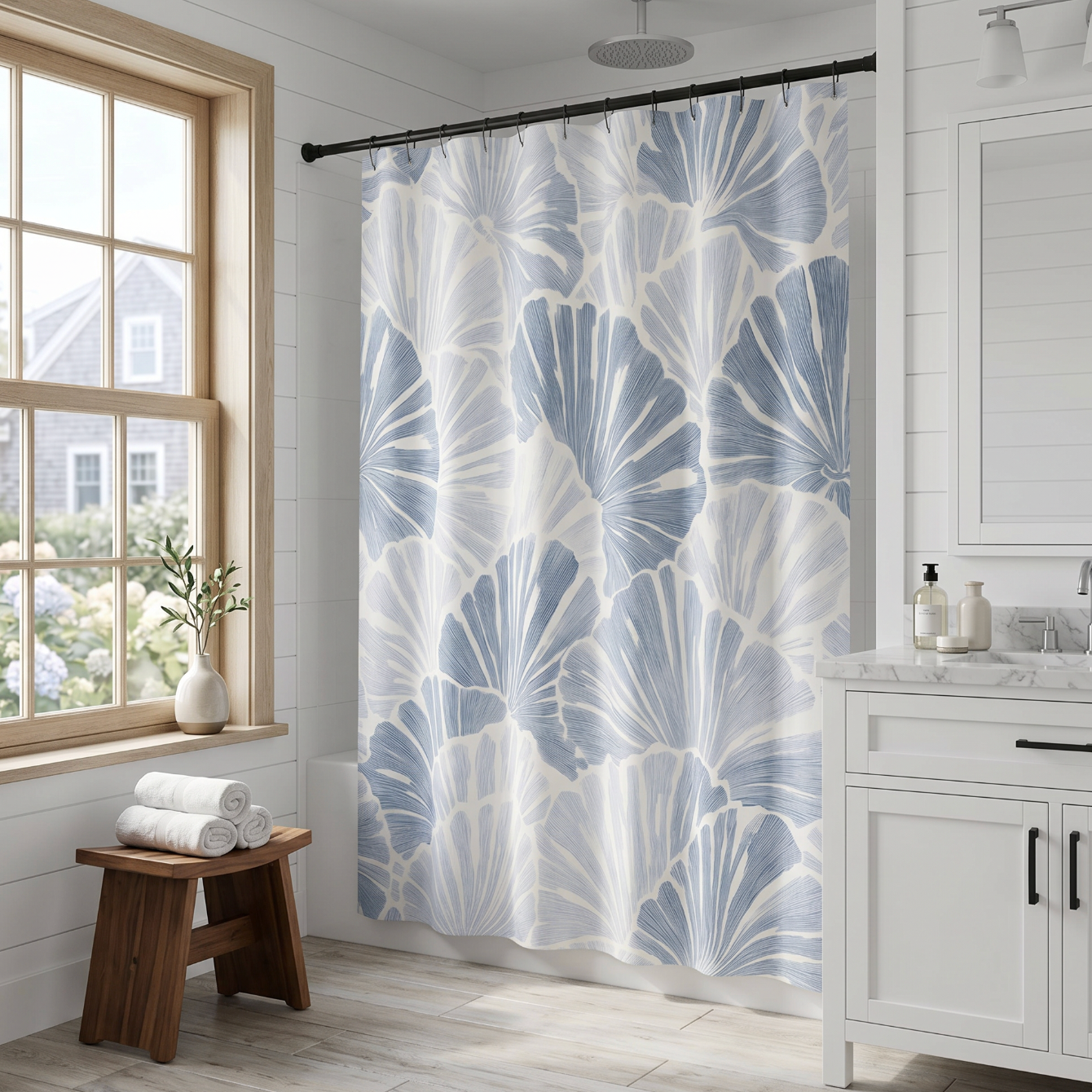 Blue and white fan shell pattern shower curtain adding a coastal look to a neutral bathroom