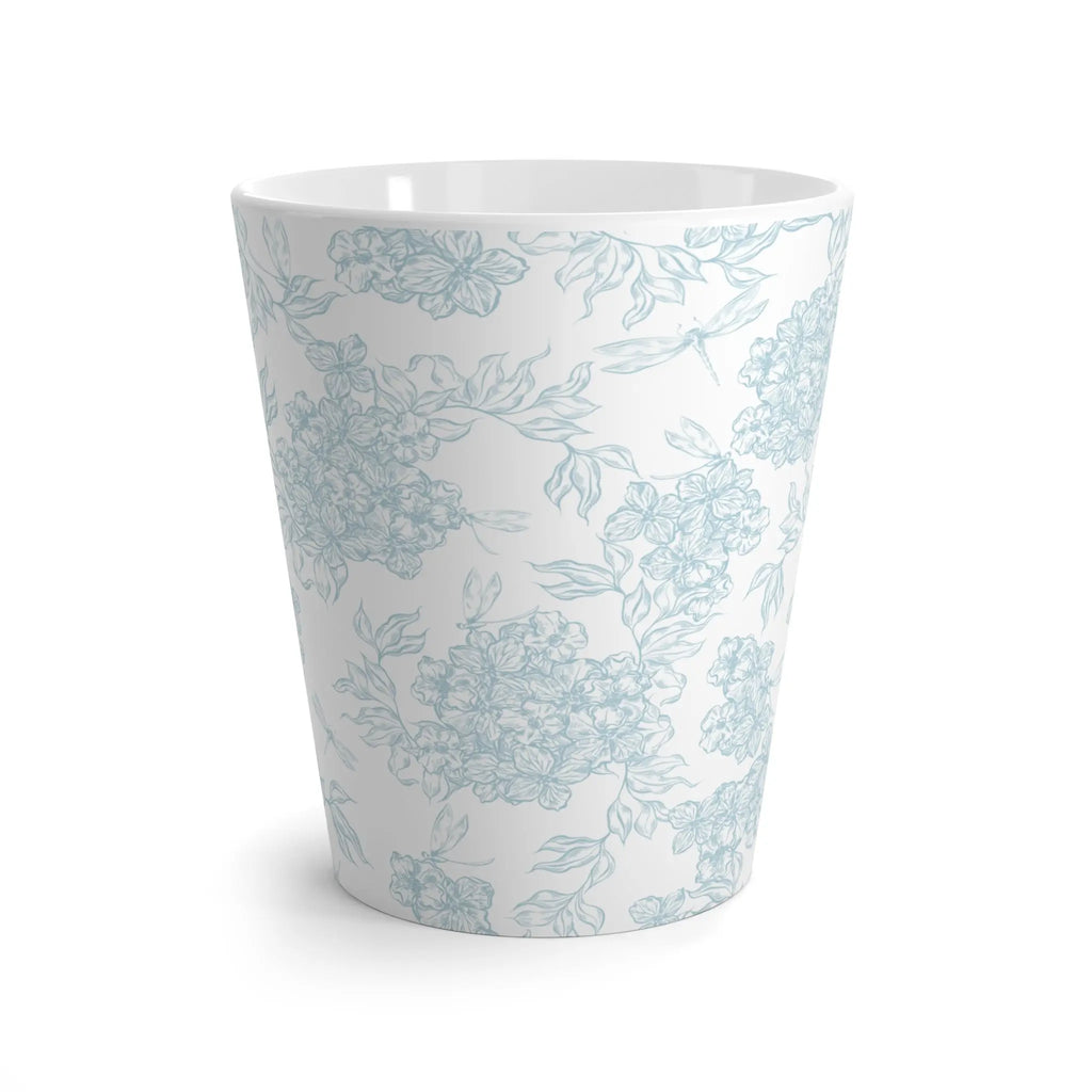 White ceramic cup with light blue floral pattern on a white background