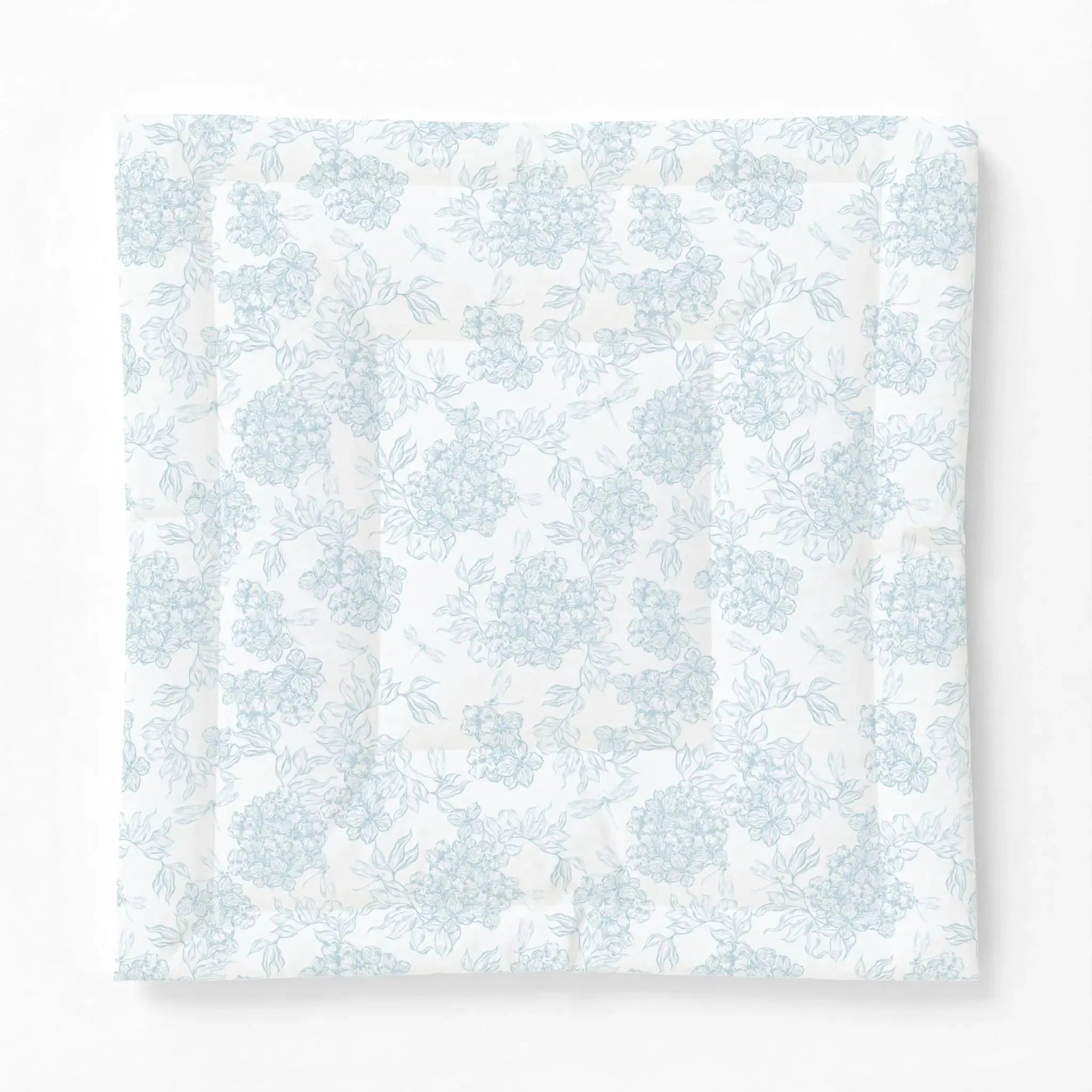 Blue and white floral comforter adding a classic coastal pattern to a neutral bedroom