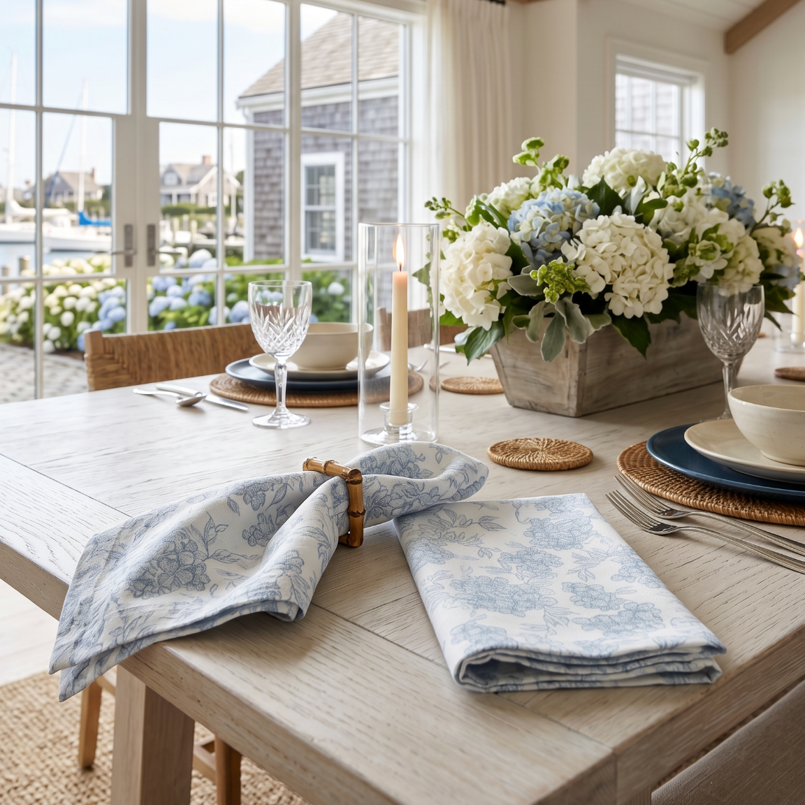 Set of 4 blue and white floral linen dinner napkins folded on a neutral coastal dining table