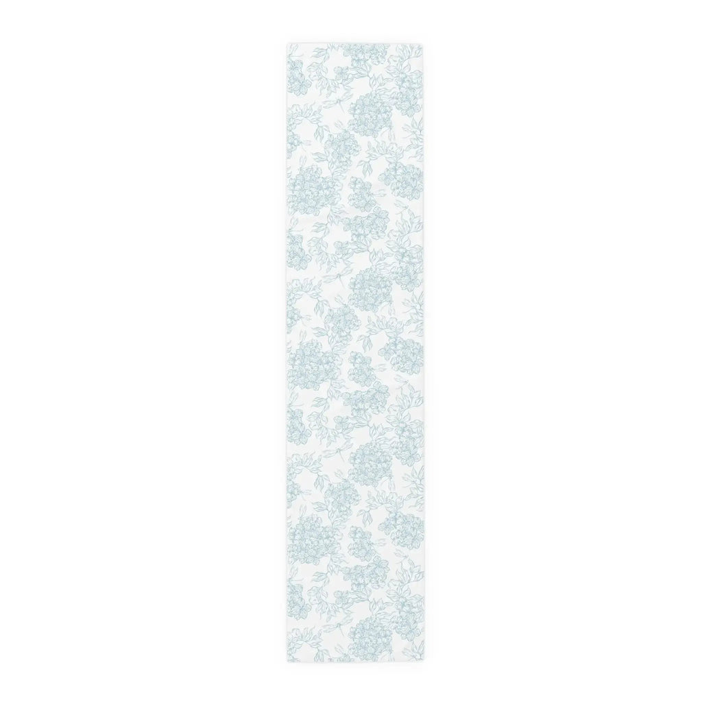 Folded blue and white floral table runner showing soft cotton fabric