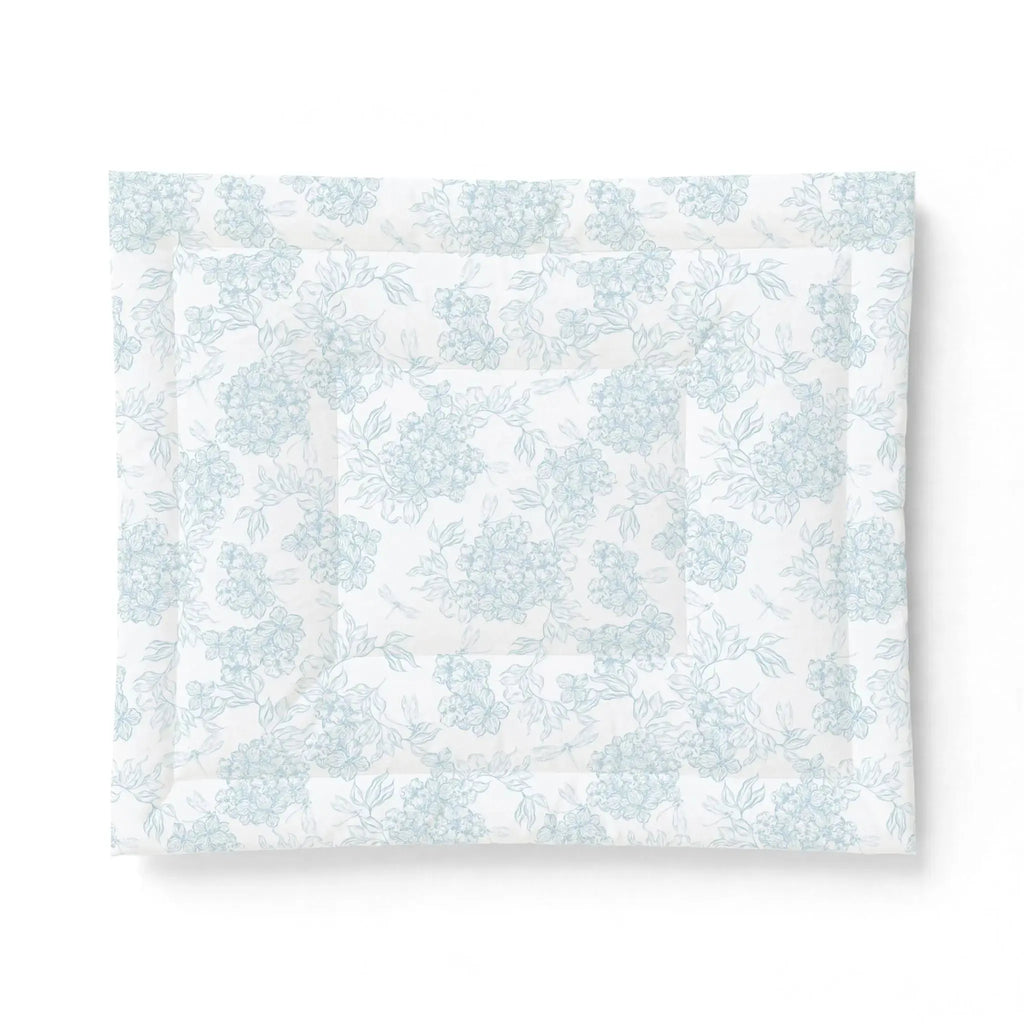 Blue and white seashell comforter creating nautical bedding in a seaside guest room