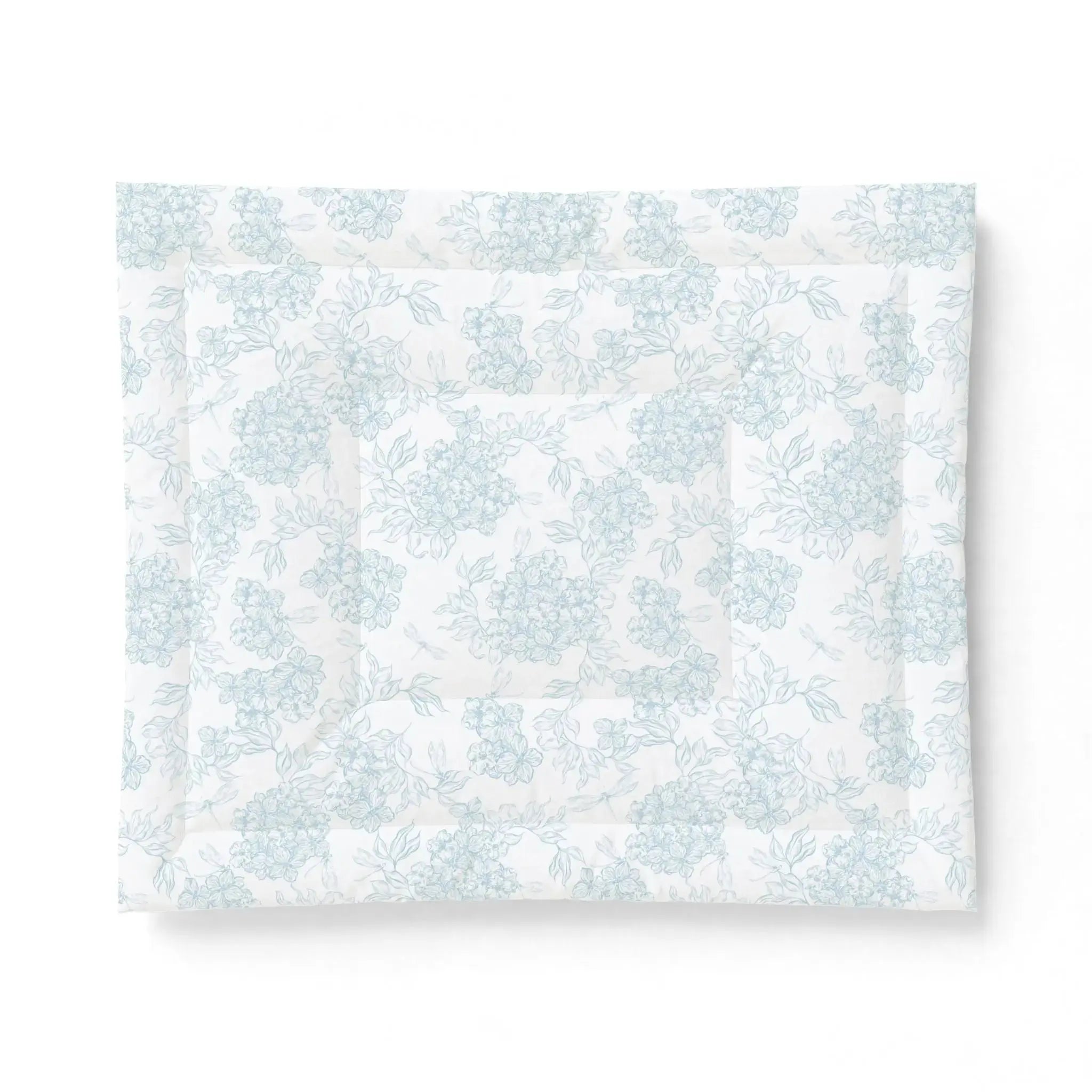 Blue and white seashell comforter creating nautical bedding in a seaside guest room