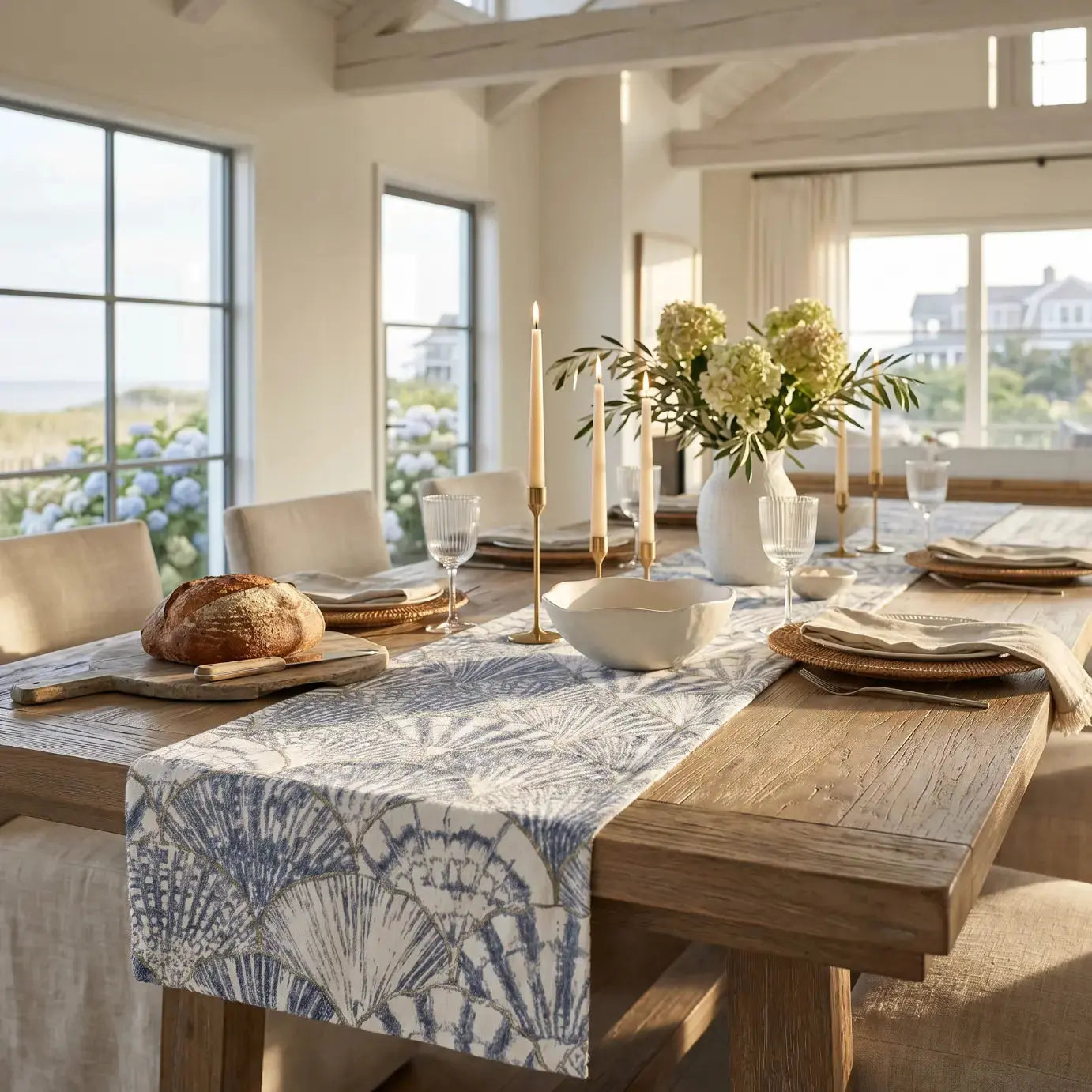 Blue and white seashell table runner styled with shell and driftwood accents in a beach house.