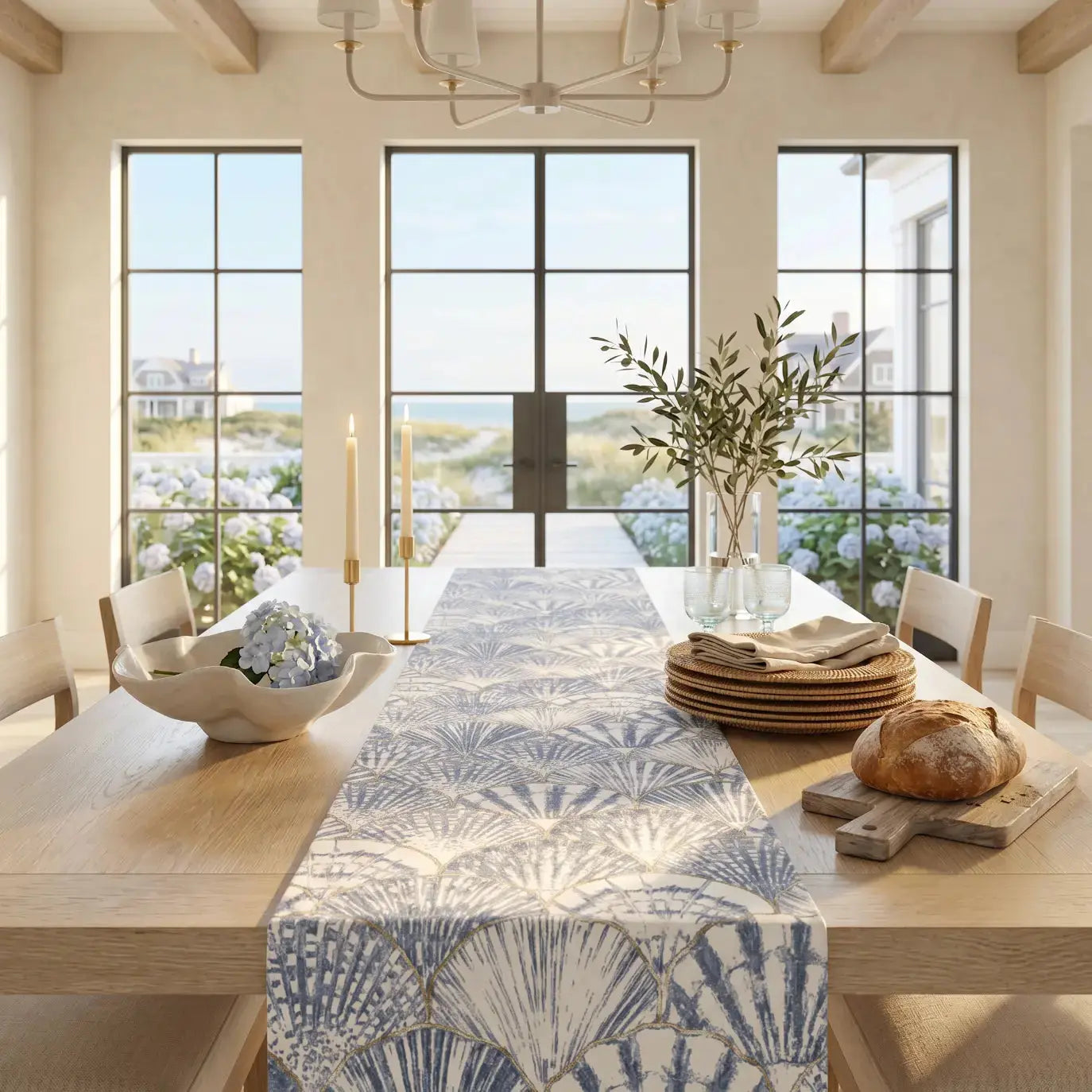 Blue and white seashell pattern table runner on a coastal dining table with white dishes.
