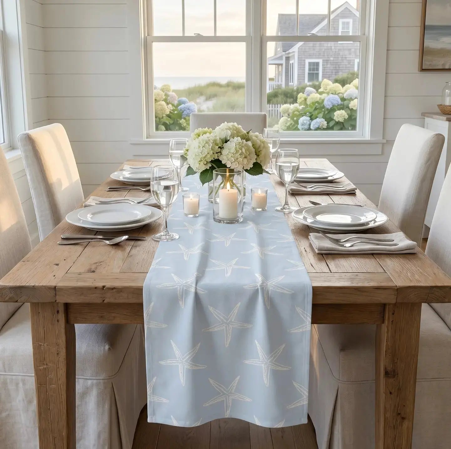 Blue and white starfish table runner on a coastal dining table.
