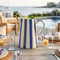 Blue and white stripe pitcher on a kitchen island styled with simple coastal decor