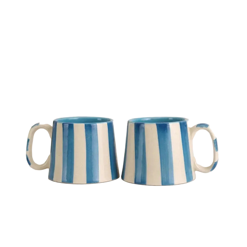 Closeup of blue and white striped ceramic cup showing painted stripe detail.