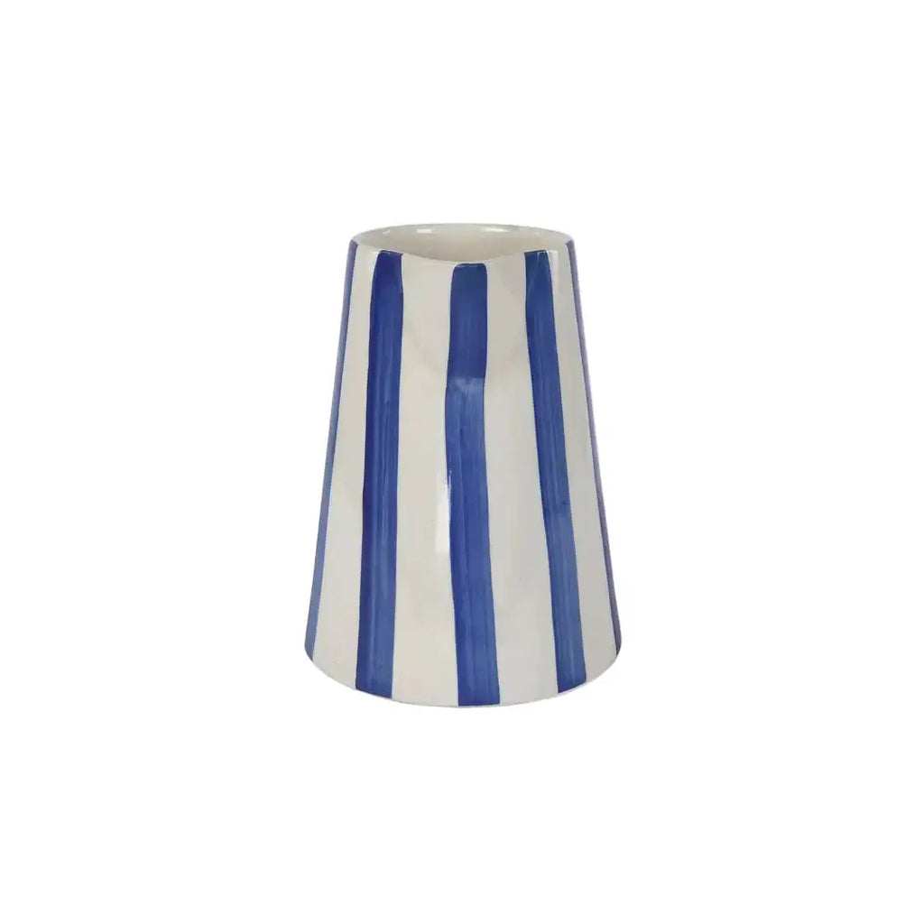 Blue and white striped pitcher filled with flowers on a table in a beach house