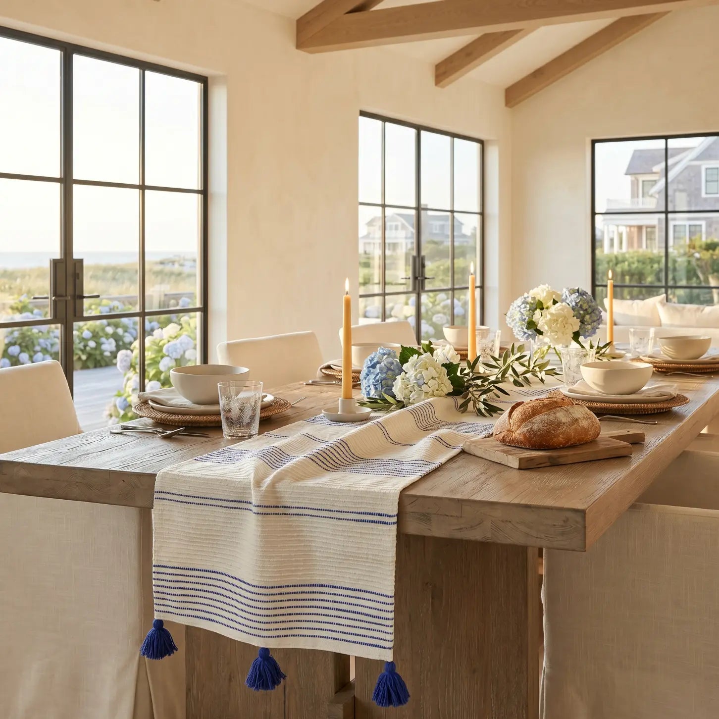 Blue and white stripe woven table runner layered over a wood table for relaxed coastal decor