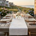 Blue and white swirl table runner on a coastal dining table with modern place settings
