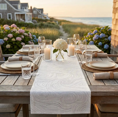 Blue and white swirl table runner on a coastal dining table with modern place settings