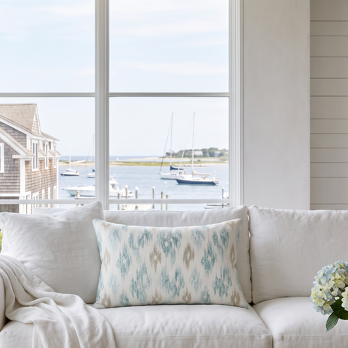 Neutral coastal ikat pattern lumbar pillow in soft blue and beige tones for beach house couch or sectional