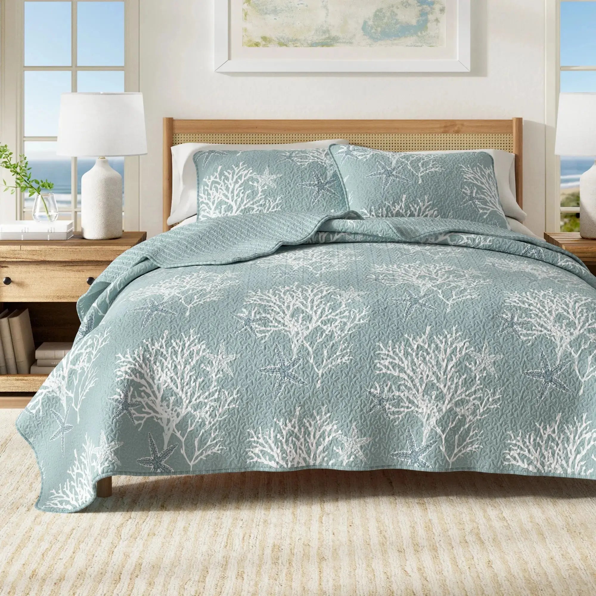 Blue coral pattern quilt set on a bed with white sheets in a coastal beach house bedroom