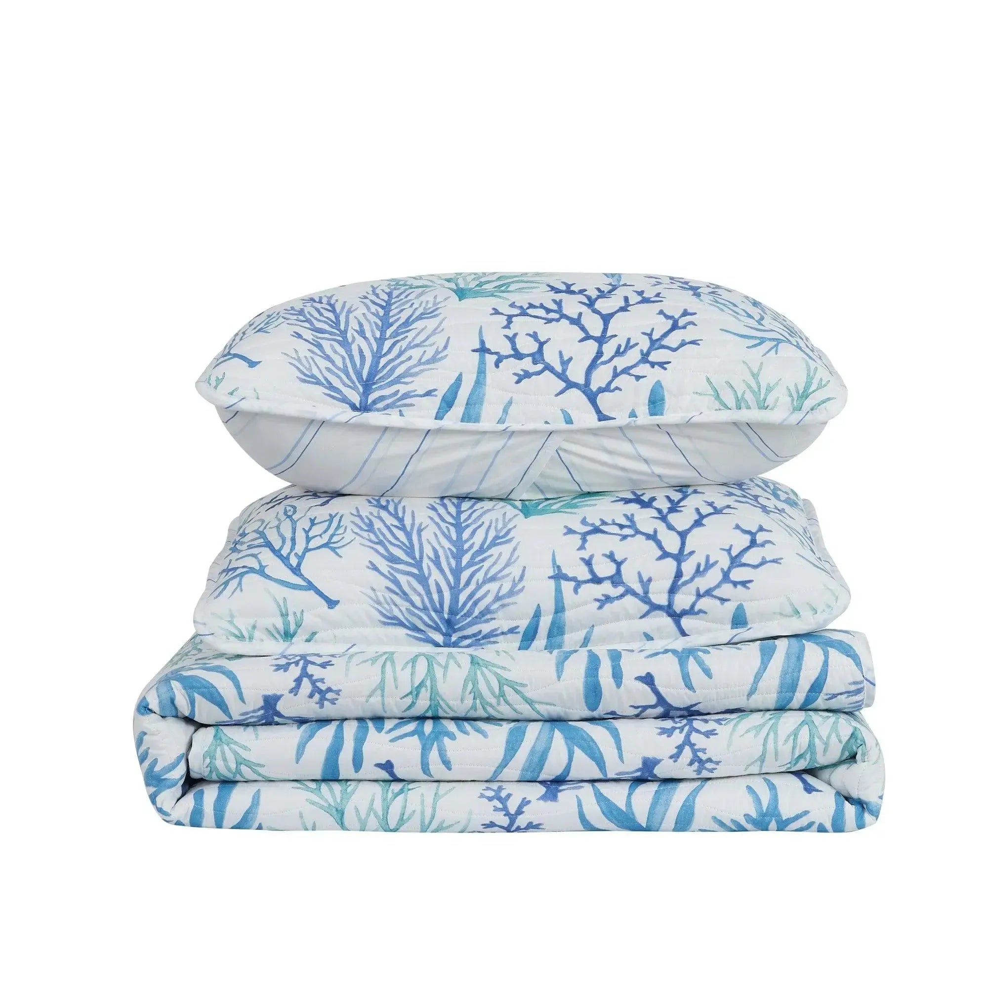 Blue coral pattern quilt adding ocean-inspired style to a neutral coastal bedroom