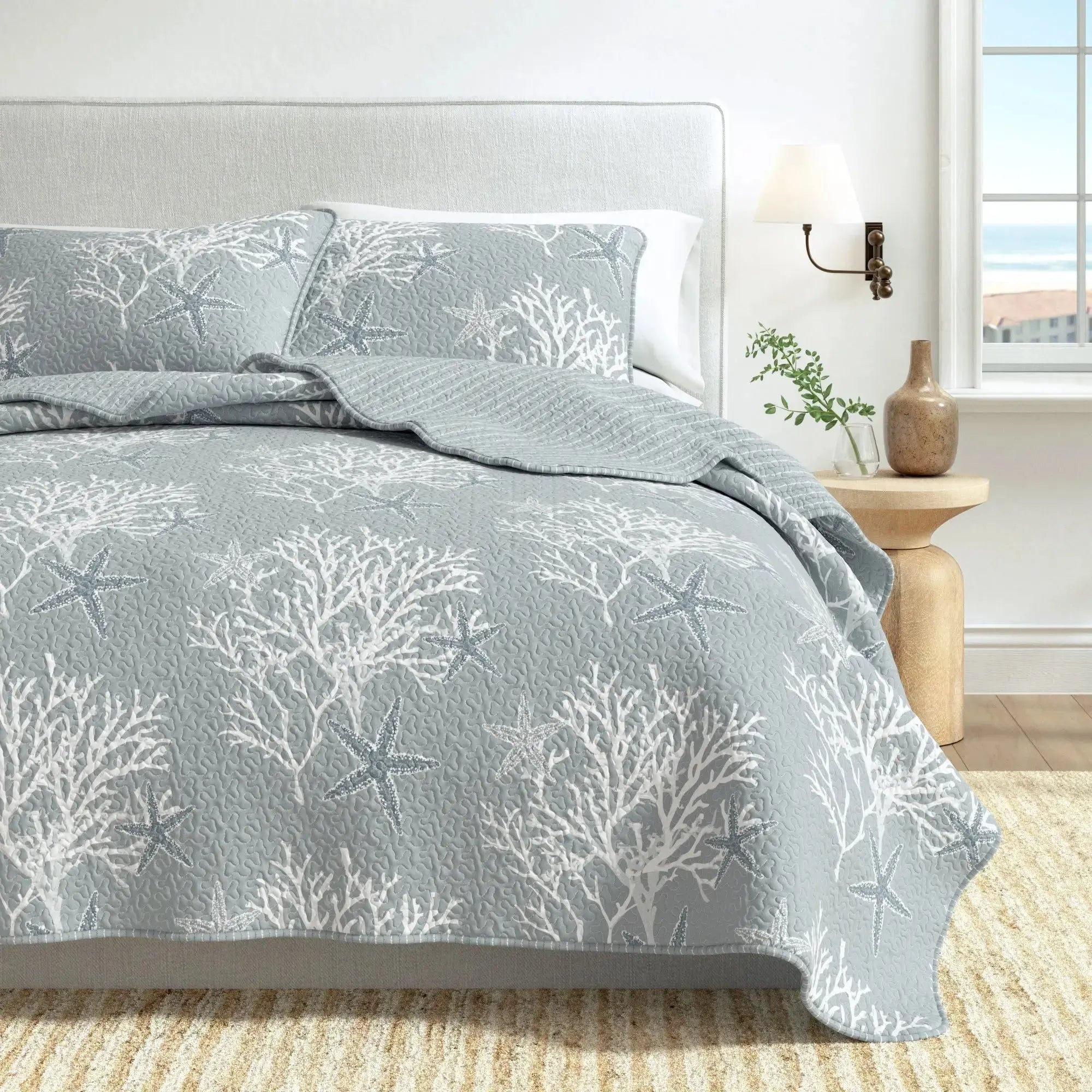 Blue coral quilt and shams adding ocean-inspired pattern to a modern coastal bedroom