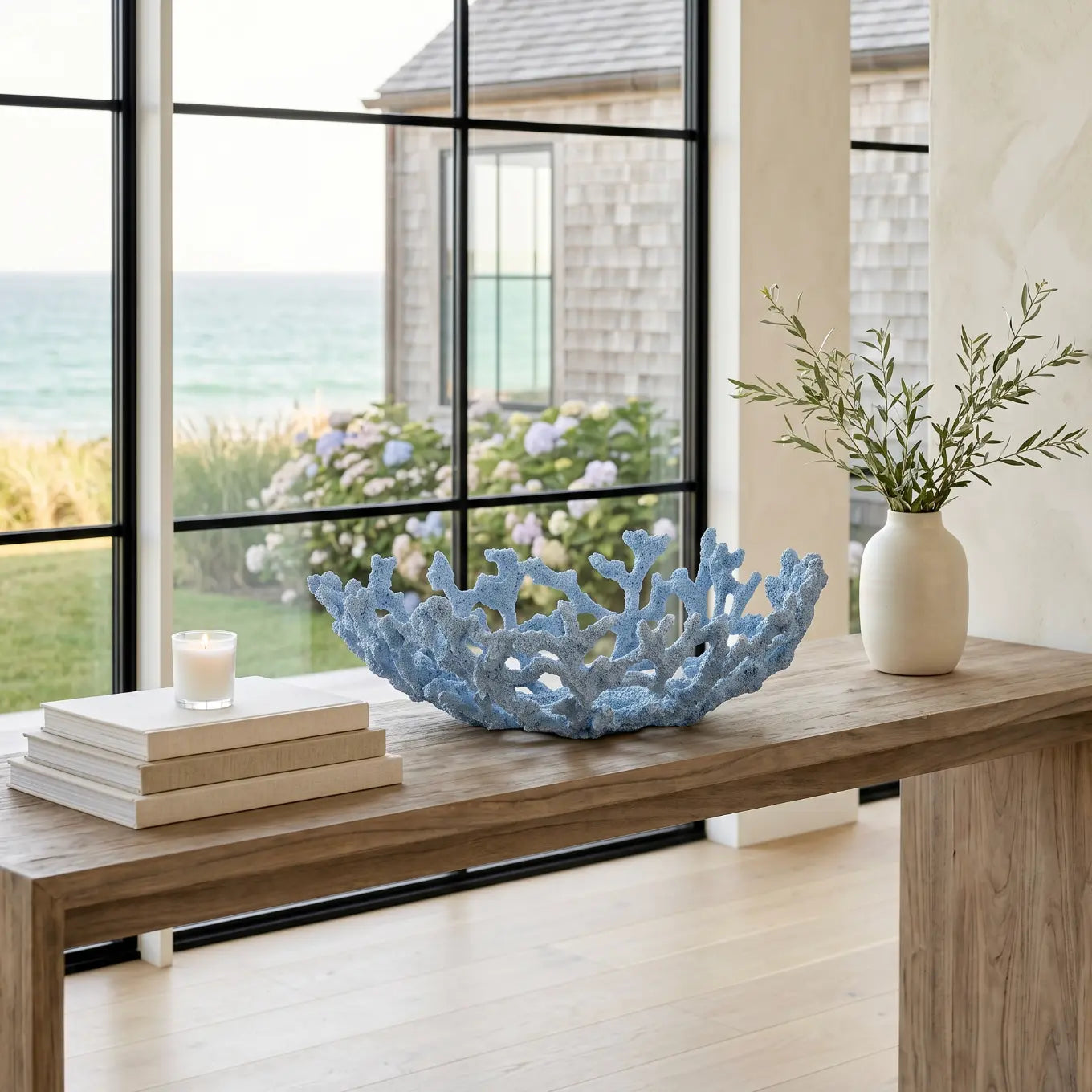 Blue coral resin bowl on an entry console table in a beach-inspired home