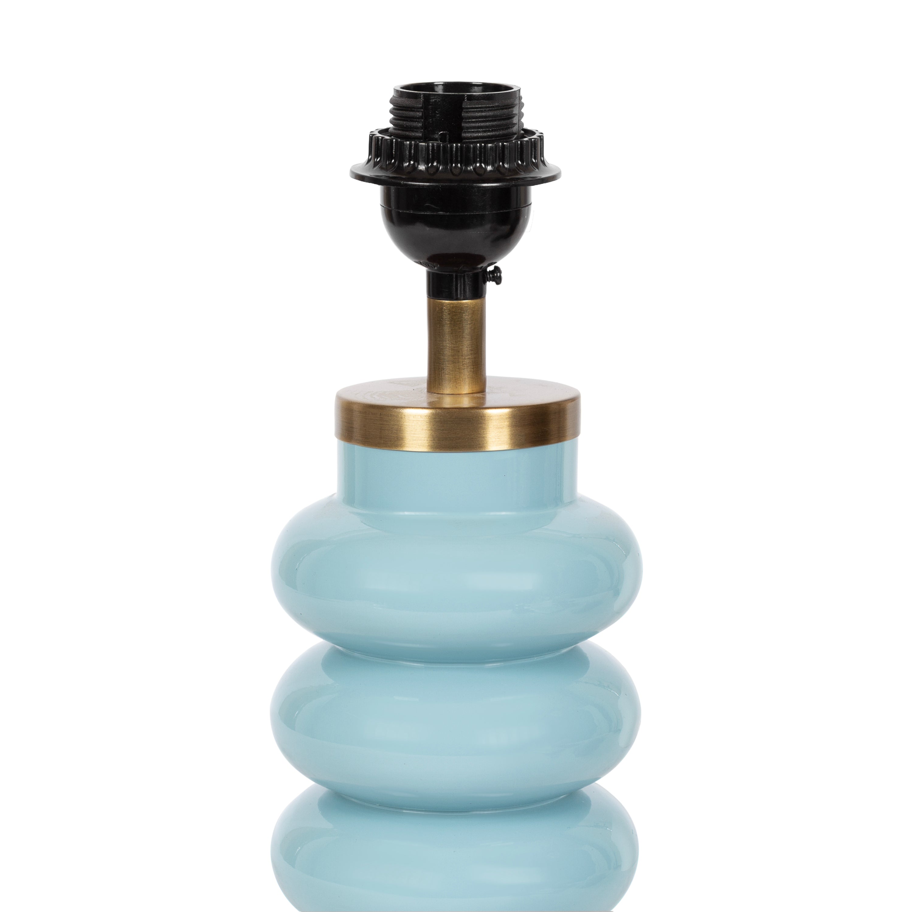Blue ceramic lamp with warm brass trim, styled beside a woven tray in a bright coastal living room.