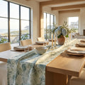 Blue and green coastal floral table runner styled on a light wood farmhouse dining table