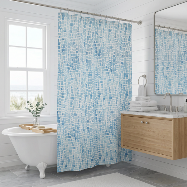 Modern coastal shower curtain with blue seaglass pattern hanging in a neutral bathroom