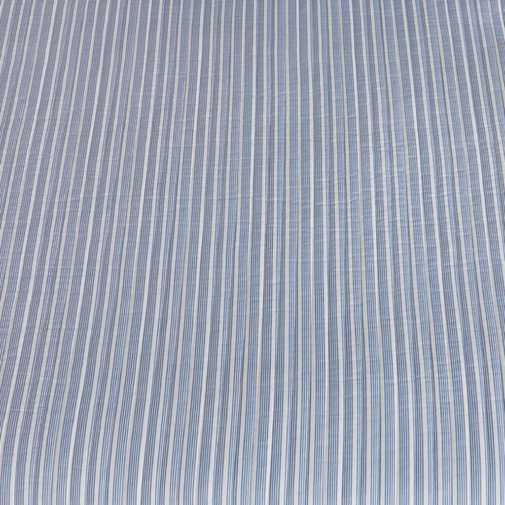 Blue striped quilt and shams creating nautical bedding in a beach house bedroom.