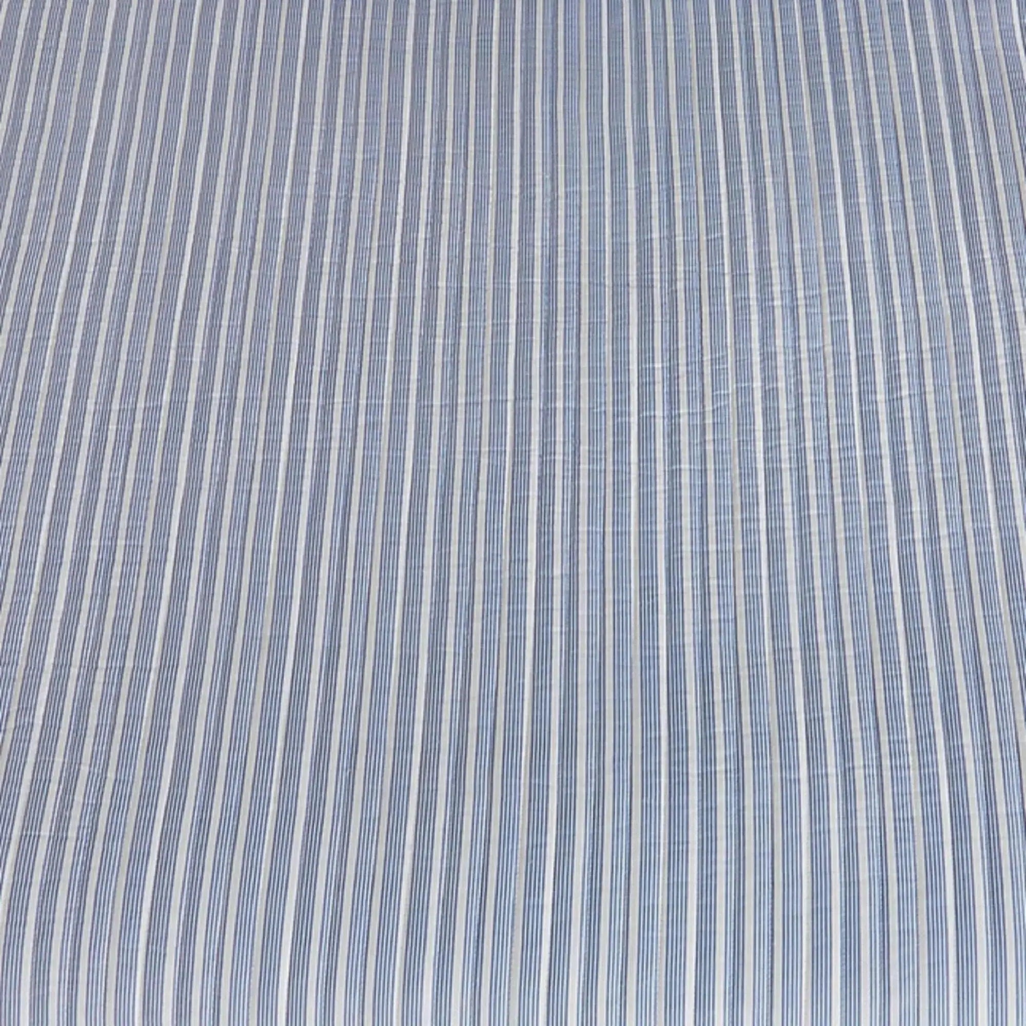 Blue striped quilt and shams creating nautical bedding in a beach house bedroom.