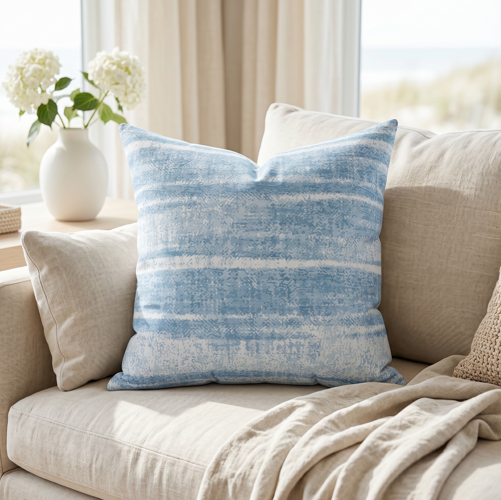 Blue washed striped throw pillow on a couch in a coastal living room