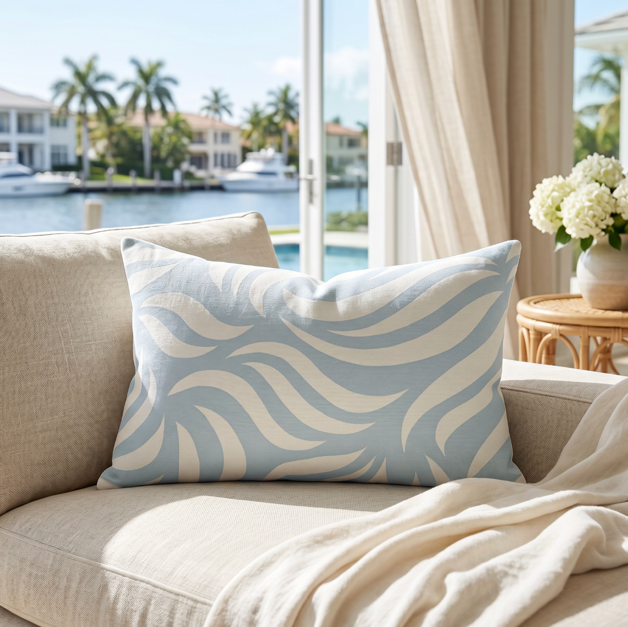 Blue and white abstract pattern lumbar pillow styled on a cream couch in a modern living room