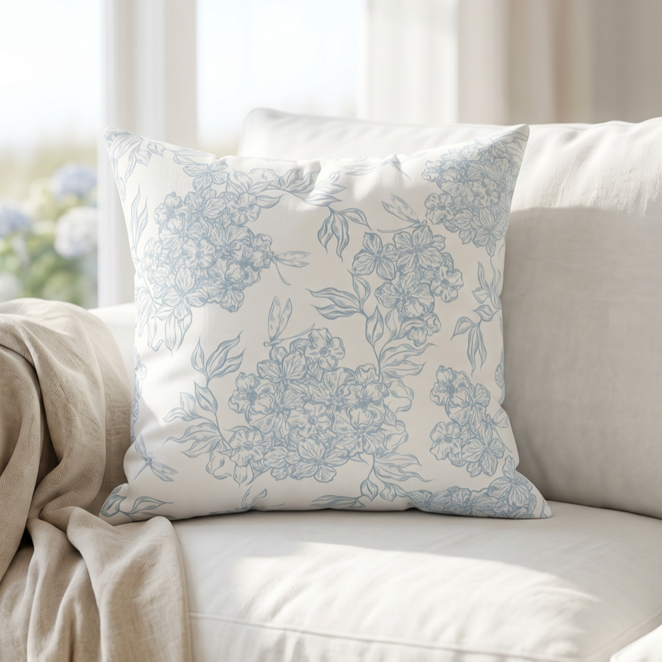 Blue and white flower pattern decorative pillow styled on a cream couch in a beach house living room